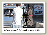 Man med bönekvarn kliver in i en bil